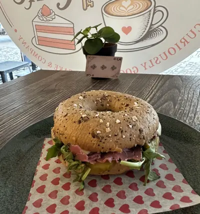 A pastrami bagel on a heart-print napkin